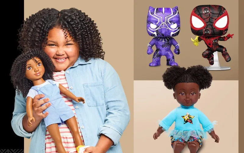 Little girl holding African American Doll with other African American dolls and action figures around her.